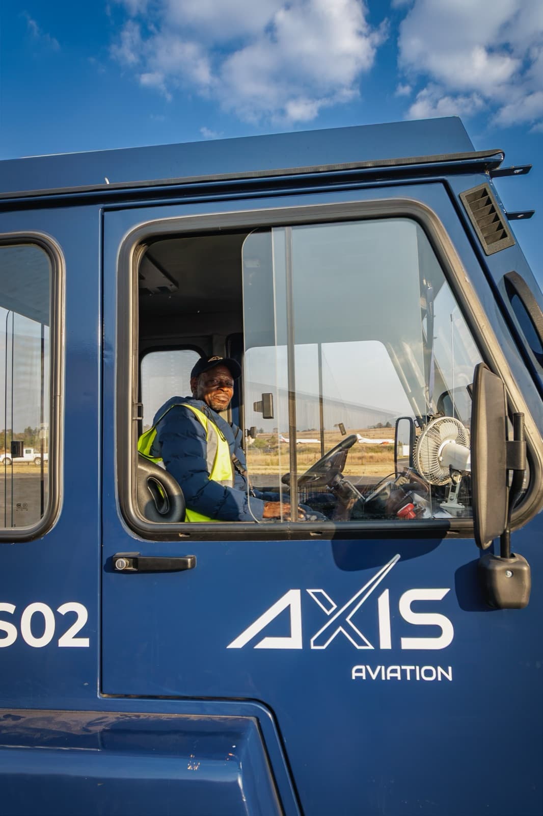 An AXIS Aviation crew member at the wheel of a ground support vehicle on the apron